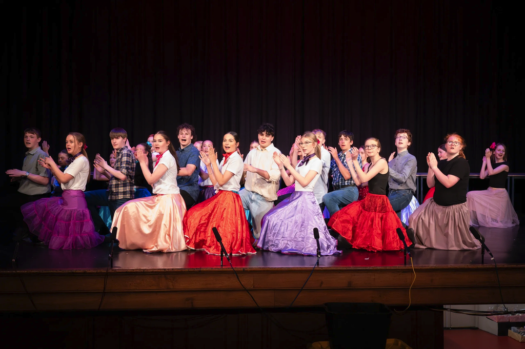 Ensemble waving flags during a big group number