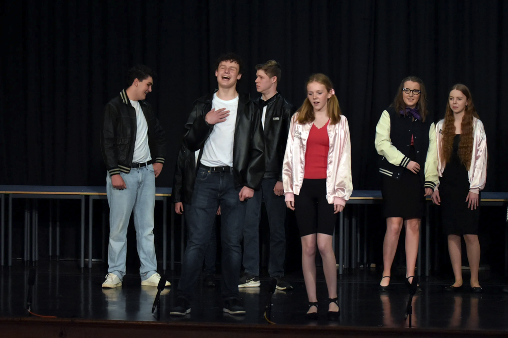 Cast sharing a laugh on stage