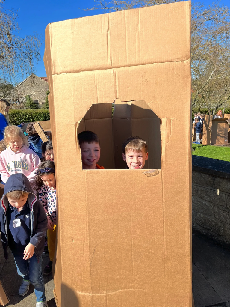 Child decorating a giant cardboard post box