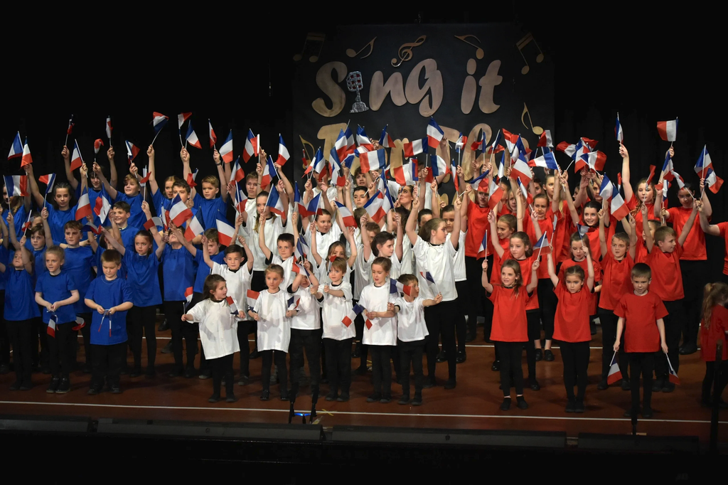Full company waving flags for the finale